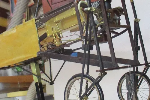 Close-up of a Blériot model aircraft showing the front fuselage, exposed engine, and landing gear structure
