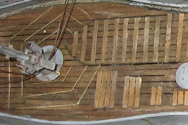 Close up of submarine model deck showing planked surface and mounted deck gun