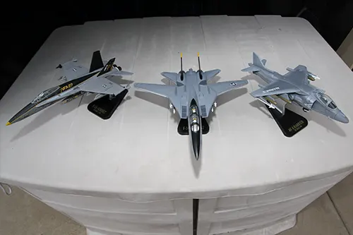 Three Super Wings jet prototype models on stands featuring F 18 Hornet, F 14 Tomcat, and AV 8B Harrier