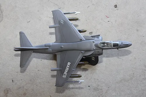 Super Wings AV 8B Harrier prototype toy model in US Marine Corps markings displayed on a stand